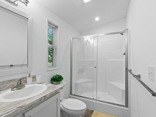 A white bathroom with a shower and sink.