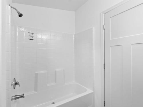 A white bathroom with a tub and shower.